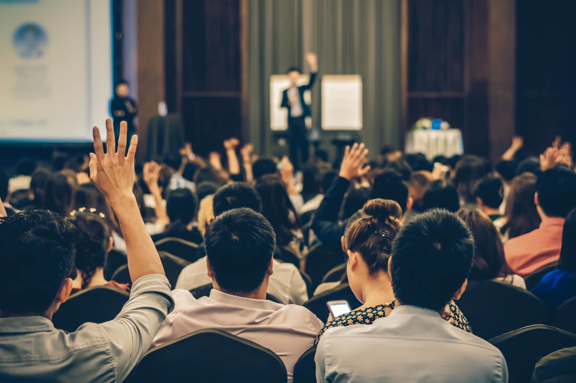 Speaker on the stage with Rear view of Audience in the conference hall or seminar meeting, business and education concept